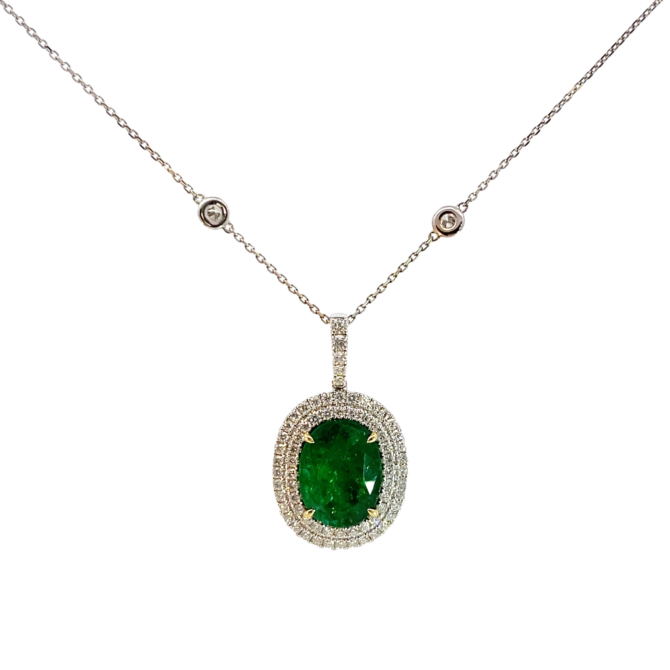 This exquisite pendant necklace features a stunning emerald gemstone, elegantly framed by sparkling diamonds. The delicate chain adds a touch of sophistication, making it perfect for any special occasion or as an everyday statement piece. Pendant-18k WG 8.59 Grams 69R-1.24 Carat 1Emerald-8.59 Carat, Necklace-14k WG 4.00 Grams 10R-0.75 Carat